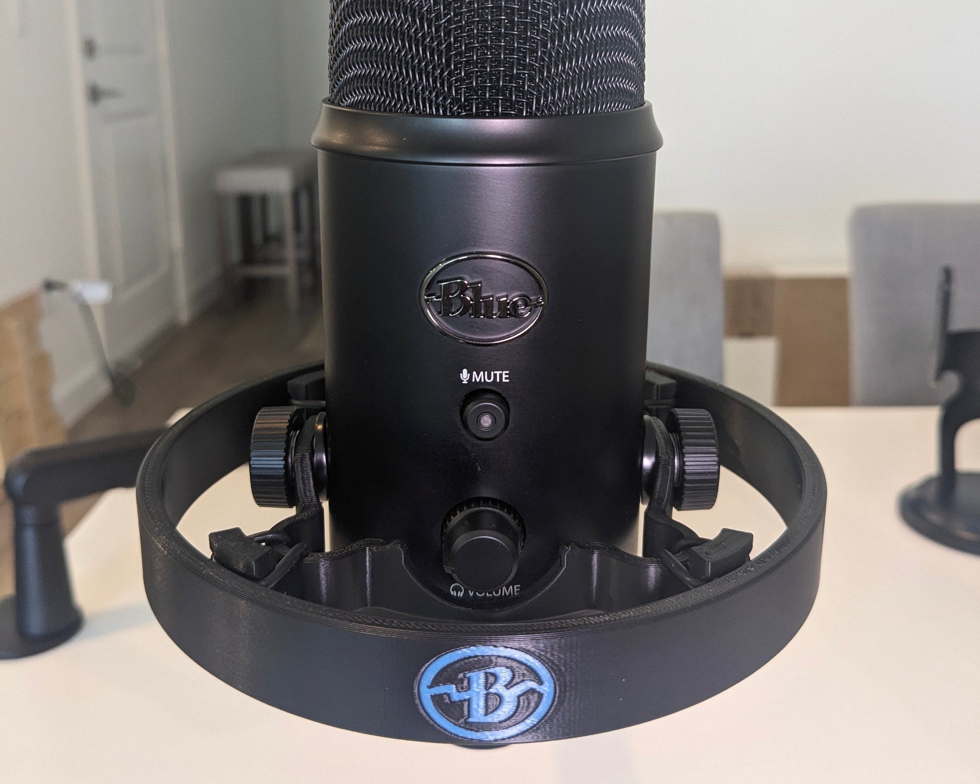 Black microphone with blue logo on a white surface